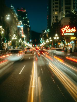 A long exposure shot of a city street at night with red and white light streaks from traffic.